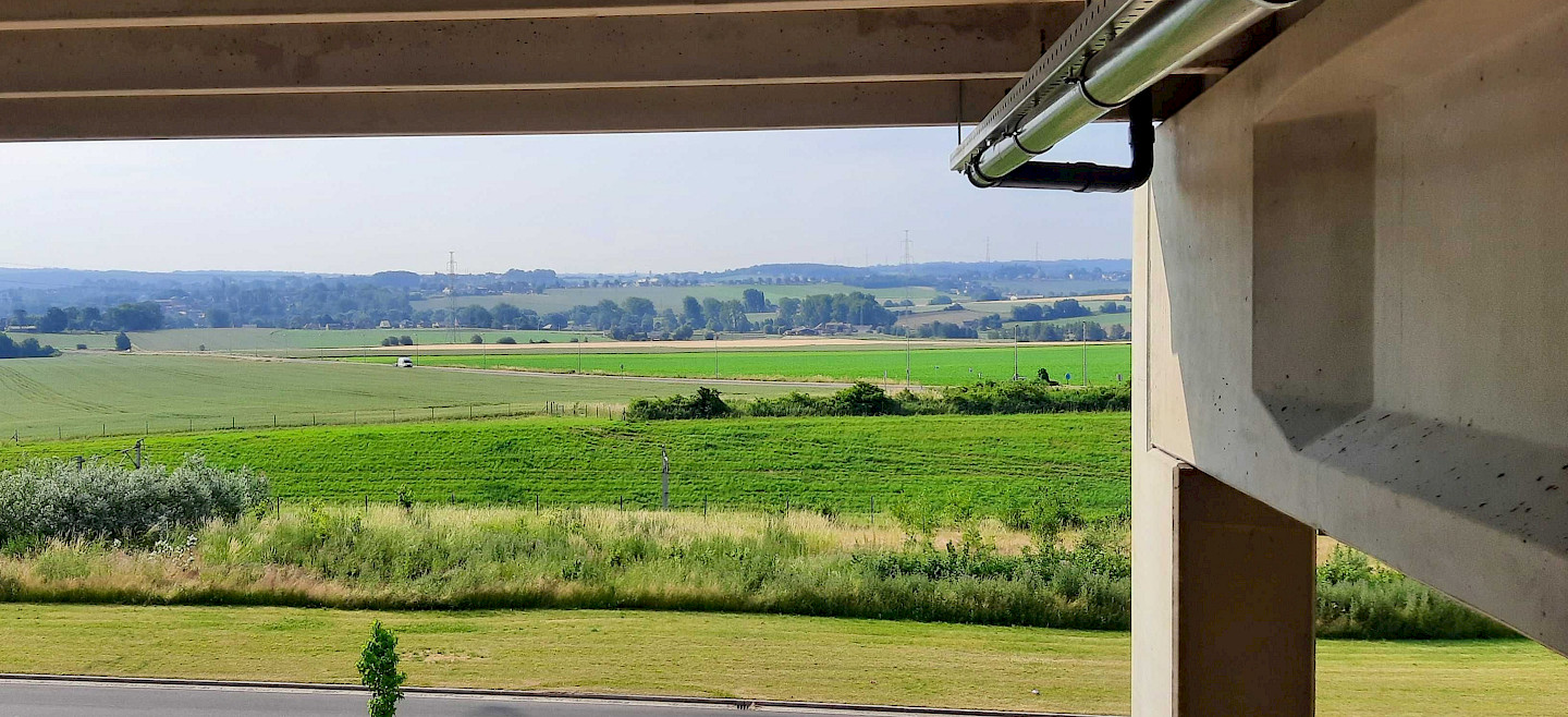 Aquadraat Nieuwbouw - zicht op een landschap vanuit een gebouw met watertechnieken